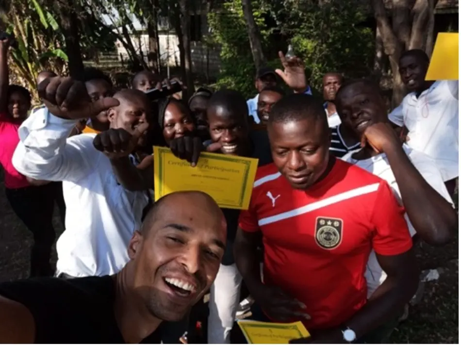 A group of participants celebrating together, holding up their certificates of participation